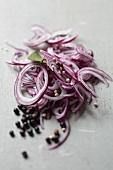Sliced red onions with juniper berries, peppercorns and a bay leaf