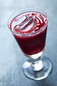 A beetroot smoothie in a glass with a stem