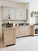 Bright, l-shaped kitchen in Shaker style with base cabinets accessible from both sides