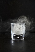 Smoking Ice in a Glass; Black Background