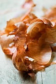 Brown onion skins on a wooden surface