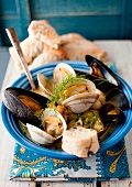 A Bowl of Mussel and Clam Stew with Fresh Dill and Bread