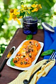 Pan Fried Yellow Tomatoes with Pistachio Caper Relish; On a Platter on an Outdoor Table