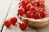 Cherry tomatoes in a wooden bowl on a wooden surface