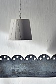 Simple lampshade and perforated metal band as minimalist wall decoration