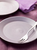 An empty plate with a dessert fork