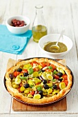Puff pastry tart with tomatoes, leek, olives and basil pesto