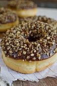 Doughnuts with chocolate glaze and chopped nuts (close-up)