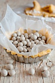 An individual tart case filled with soya beans for blind baking
