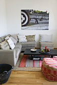 Corner sofa and comfortable pouffe next to dark wood coffee table