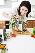 A woman seasoning a dish in a saucepan