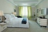 Doppelbett mit gepolstertem Kopfteil gegenüber postmoderner Kommode in klassischem Schlafzimmer