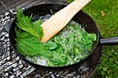 Stinging nettle leaves being fried in oil