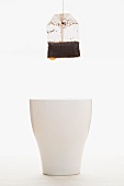 A tea bag dripping into a white mug