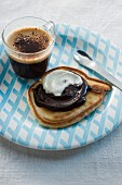 A pancake with chocolate sauce, served with coffee
