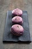 Three purple macaroons on a paper napkin