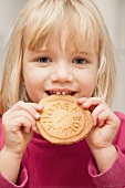 A young girl eating a home-made biscuits