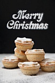Mince pies, with 'Merry Christmas' written in the background