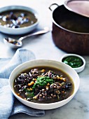 Duck and lentil soup with snails and garlic and parsley oil