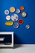 Colourful wall plates on blue wall
