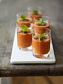 Mehrere Gläser Gazpacho mit Basilikum