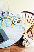 Breakfast table jazzed up in youthful style with map of the world applied to table top and vintage chairs