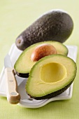 A whole and a halved avocado