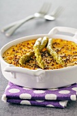 Carrot custard flan with poppy seeds and green asparagus