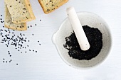 Black sesame seeds in a mortar and sesame seed toast
