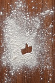 A 'like' symbol in flour on a wooden surface