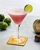 A Cosmopolitan on a Coaster with a Lime Slice Garnish