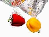 Red and Yellow Bell Peppers Splashing into Water