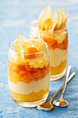 A layered dessert with apricots, caramel mousse and physalis