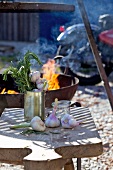 Garlic and rosemary on a wooden board in front of the barbecue, with a motorbike in the background