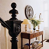Treppengeländer mit schwarzem Pfosten und kugelförmigem Abschluss gegenüber Konsolentisch in Hausflur