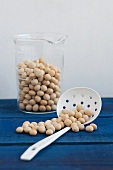 Soy beans in a measuring jug and on a draining spoon