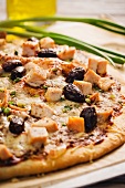 Pizza mit BBQ-Sauce, Hähnchen und schwarzen Oliven