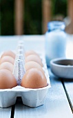 Fresh Eggs in a Carton on an Outdoor Table