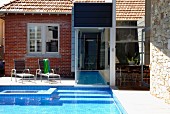 Renovated house with brick, glass and stone facade; garden pool with connection to interior pool