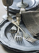 Old silver forks on a pewter plate