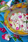 Cream cheese ice cream with geranium petals and basil coulis