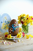 Chocolate Easter egg, sugar eggs and a small bunch of narcissi