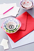 Flower decoration made from paper cake cases on envelope