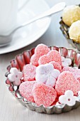 Small cake mould used as dish for sweets & flower-shaped sugar cubes