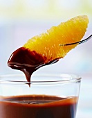 An orange segment with chocolate dip