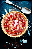 A Bakewell tart with glacé cherries, slivered almonds and sugar icing