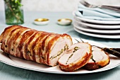Roast pork wrapped in bacon, partly sliced
