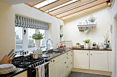 Bright, country-house-style fitted kitchen with glass ceiling