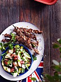 Grilled Australian lamb kebabs served with potato salad with green beans, avocado and bacon