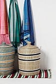 Hängende Tücher über Wäschekörben auf buntem Webteppich